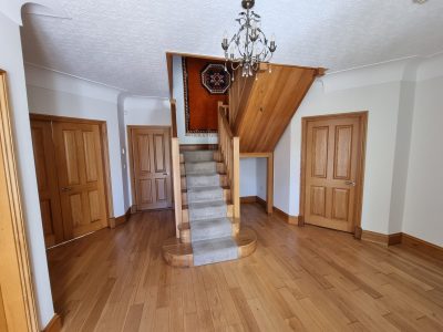 a wooden staircase leading to a hallway with wooden flooring in a home scaled