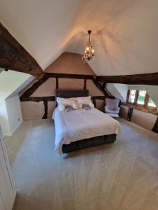 a bedroom featuring wooden beams and a white ceiling rotated