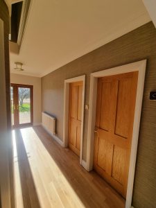 a hallway in a home decorated in a brown wallpaper rotated