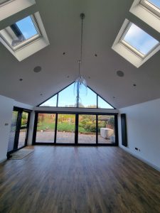 a large living space illuminated by bifold doors featuring a white decor painted by mc painters rotated