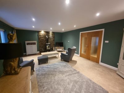 a stylish living room painted in a green colour by mc painters