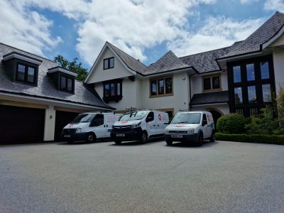 mc painted vans parked in front of a contemporary home featuring a white painted exterior