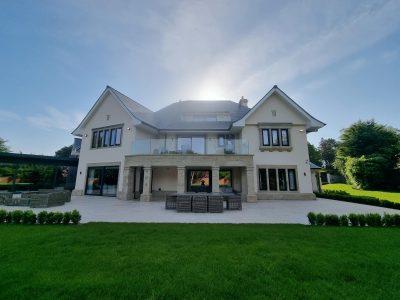 the painted exterior of a large contemporary home featuring a glass balcony
