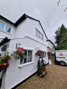 white painted exterior of a pebble dash home rotated