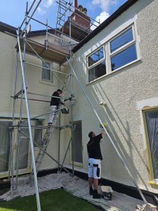 mc painters decorating a house while using scaffolding